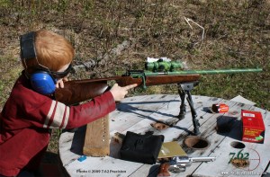 A five-year-old boy getting into a position to fire his Savage Cub T. This well-designed .22 rifle, with Savage's AccuTrigger, is ideal for training children.