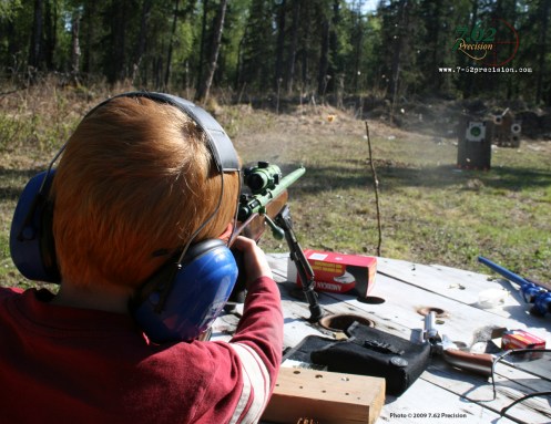 Apple Fragments fly as a six-year-old launches a bullet from a Savage Cub .22 rifle. Targets that react to a hit keep shooting fun for children.